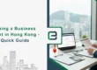 Business professional reviewing documents at a desk with laptop and Hong Kong city skyline in the background, representing a quick guide to opening a business bank account in Hong Kong.